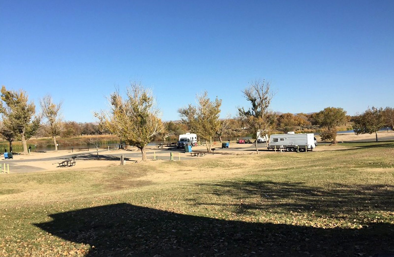 A large grass area with RVs parked.