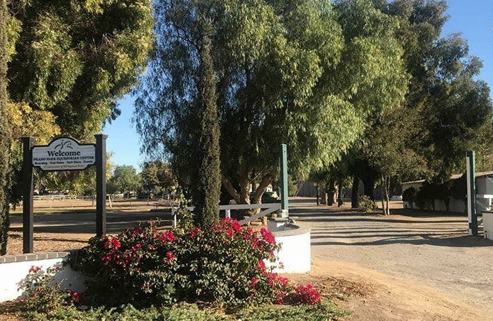 Outside Prado Equestrian Center entrance with flowers and trees.