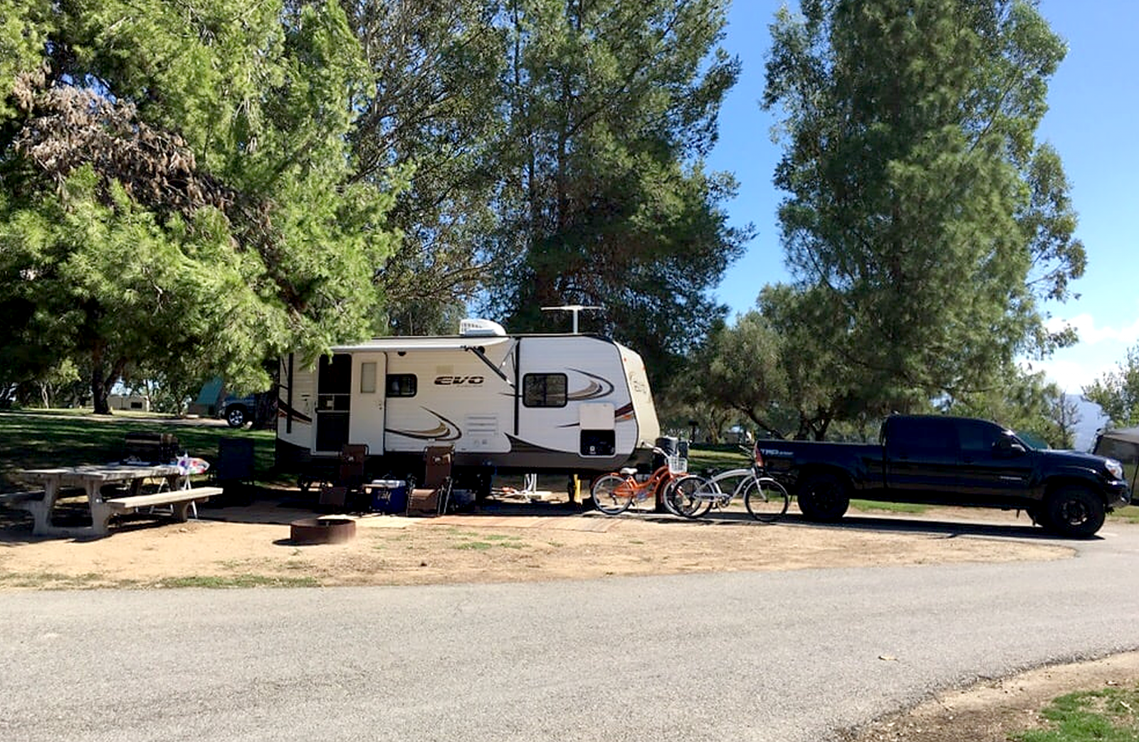 Prado RV camper parked under a tree.