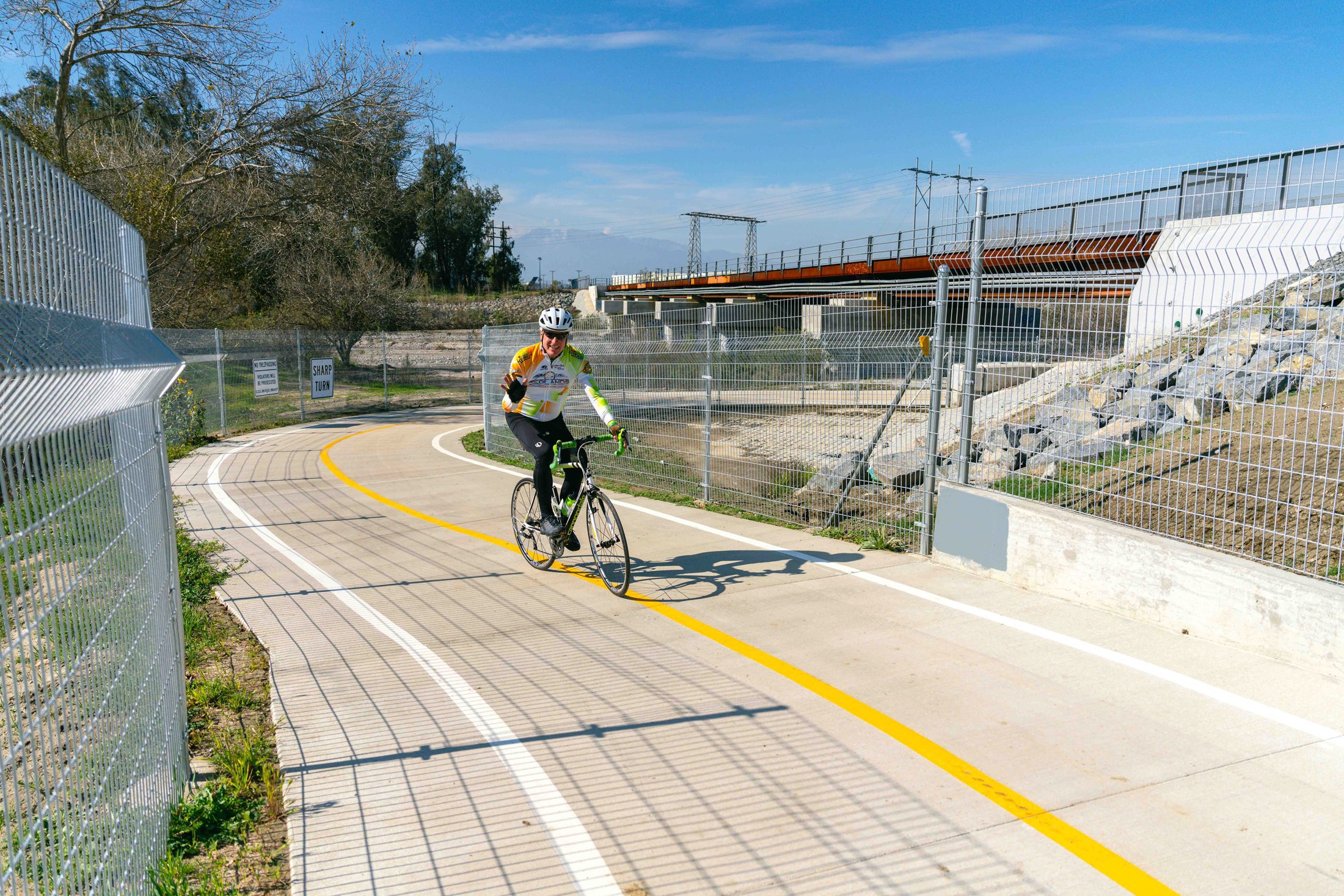 A man dressed in cycling gear and helmet rides a stretch of the Santa Ana River Trail in San Bernardino.