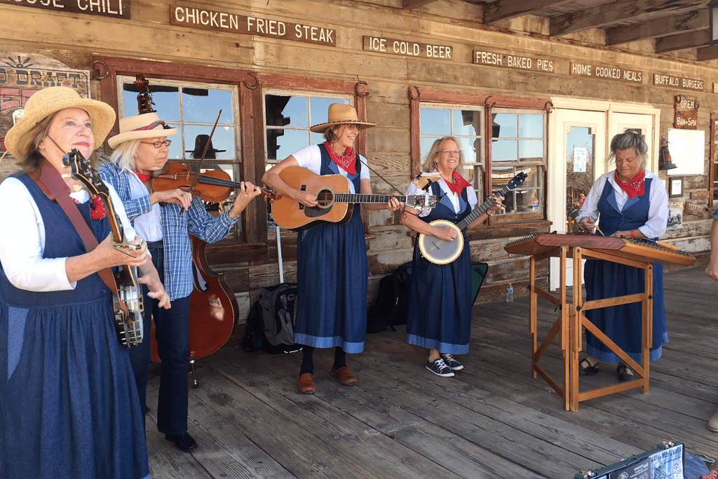 Female bluegrass/country band members are shown playing the fiddles at Calico Bluegrass Festival in 2023.