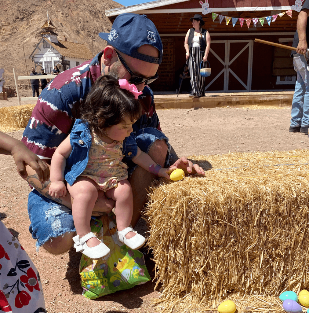 A father holds his daughter while hunting for Easter eggs at Calico Ghost Town in 2022.