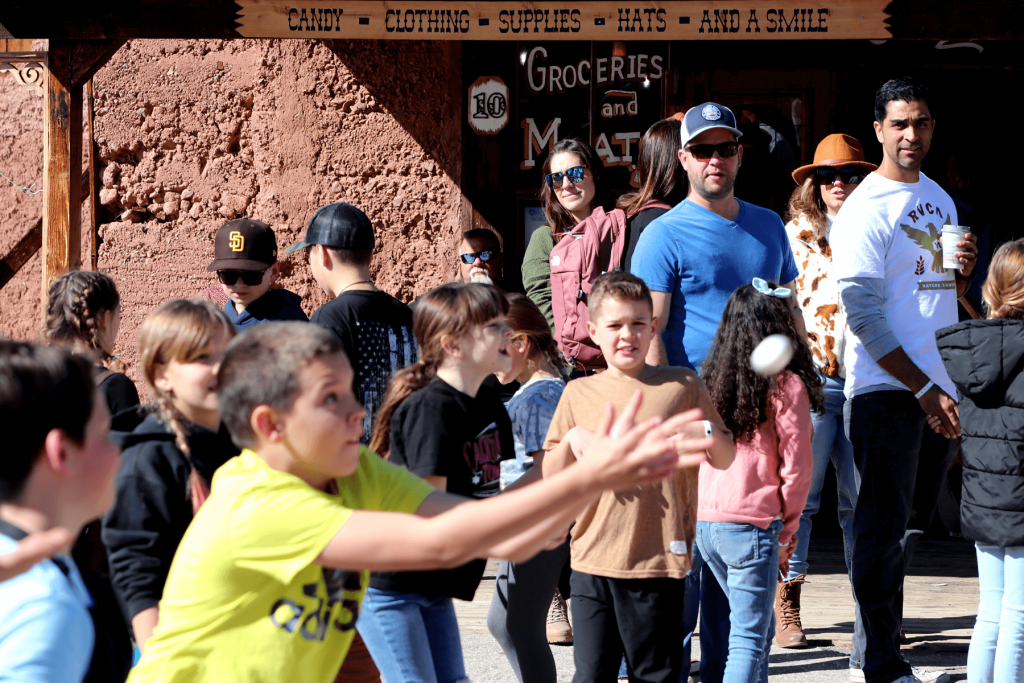A boy throws an egg while people watch at Calico Ghost Town in 2023.