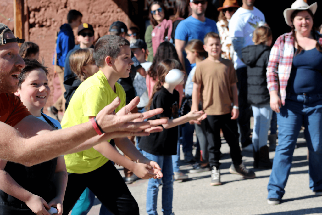 A group of kids and adults playing the game of egg toss at Calico Ghost Town for California Days in 2023.