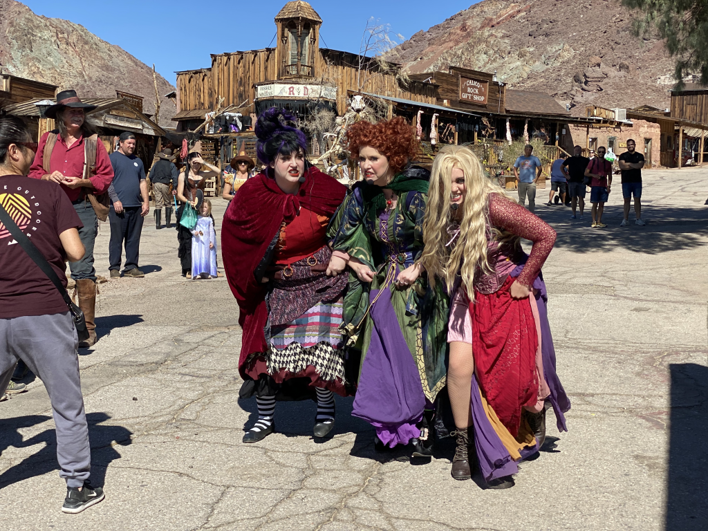 A trio of women dressed as Hocus Pocus characters running through Calico Ghost Town during the Ghost Haunt event in 2023.