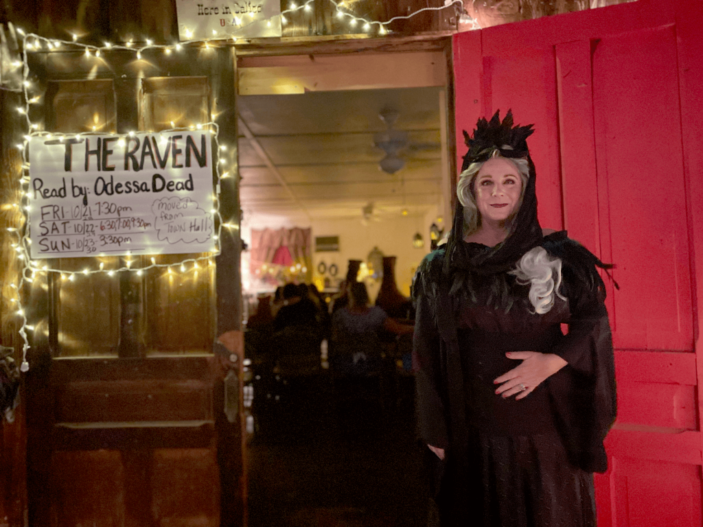 A woman dressed up in dark attire matching the reading of Edgar Allen Poe's The Raven.