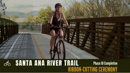 A woman riding a bike over a bridge.