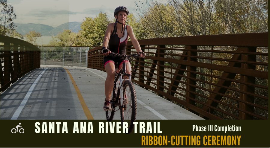 A woman riding a bike over a bridge.