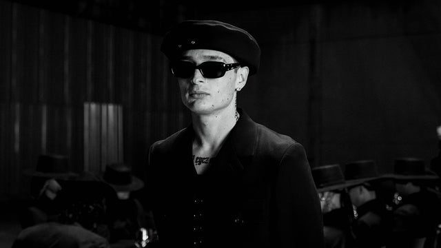 Peso Pluma wearing a beret and dark sunglasses