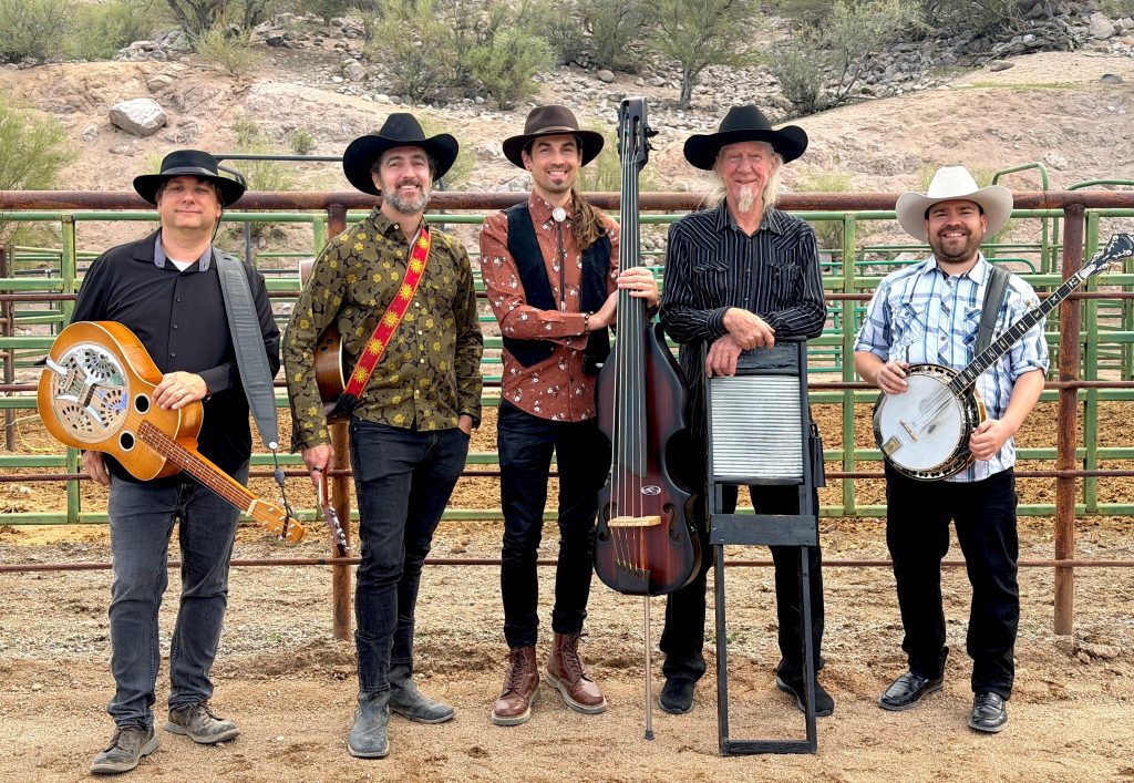 Five male band musicians stand holding instruments.