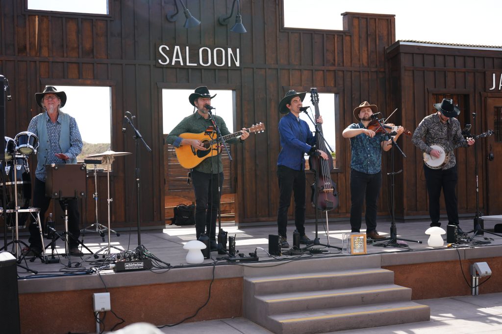 The Storytellers band, group of musicians onstage in front of an old Western saloon facade at Calico Ghost Town.