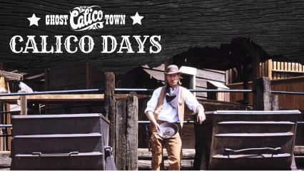A man dressed in Western wear stands while holing a mining pan at Calico Ghost Town.