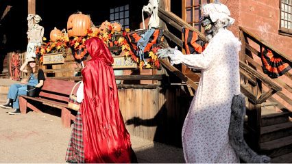 Two people dressed in Halloween costumes as the Big Bad Wolf and Little Red Riding Hood walk through Calico Ghost Town.
